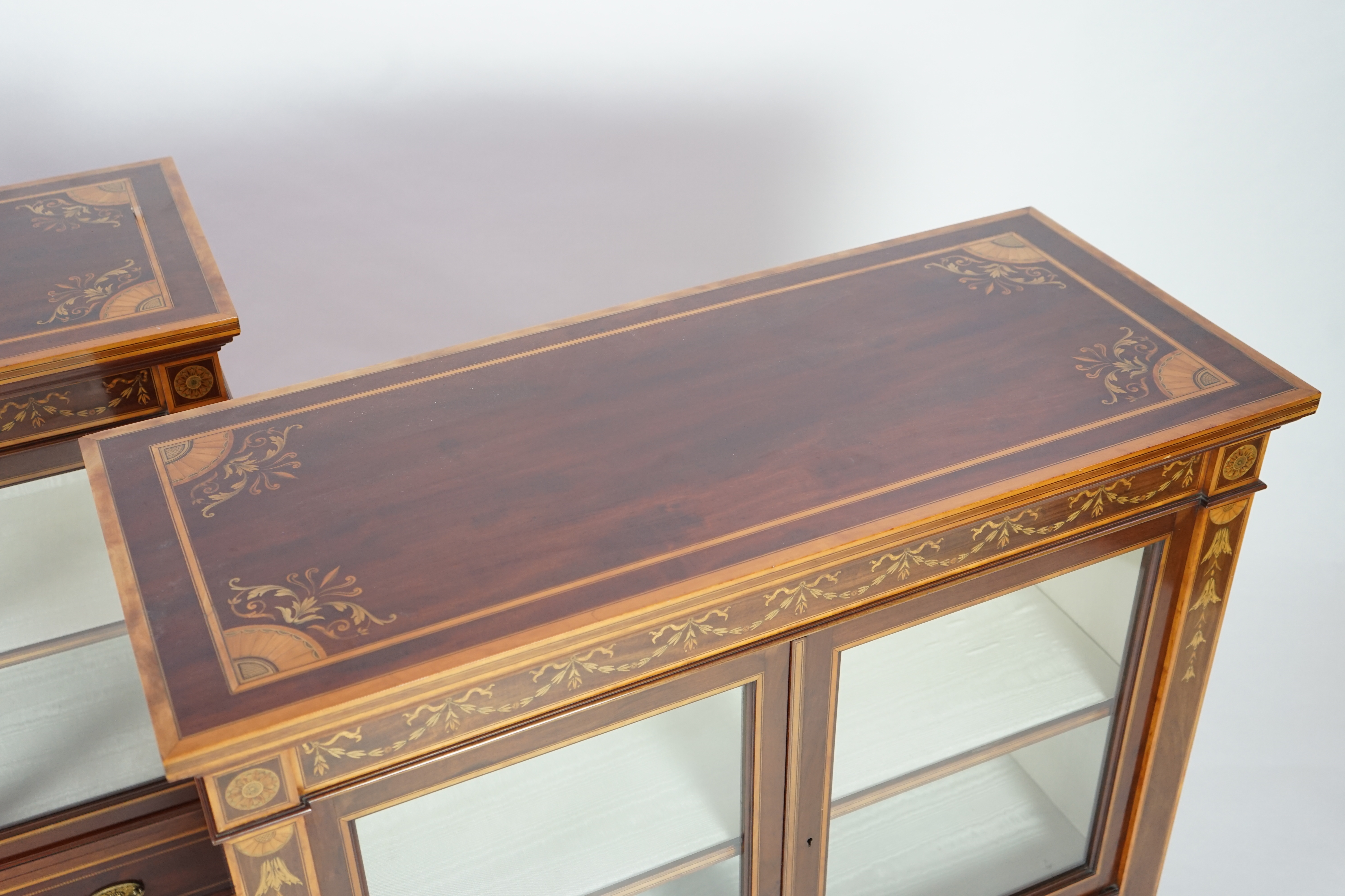 A pair of Edwardian marquetry inlaid and satinwood banded mahogany side cabinets, by Gillows